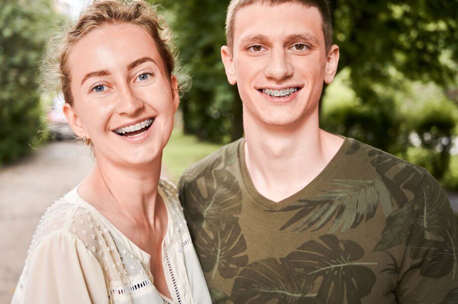 a young couple wearing braces smiles