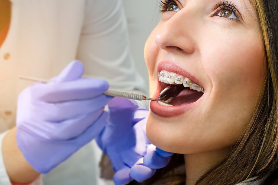 a smiling dental patient has their braces checked