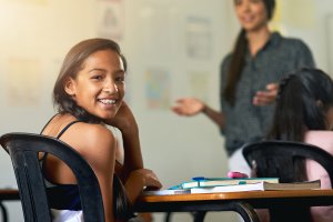 a teen with braces smiles in class